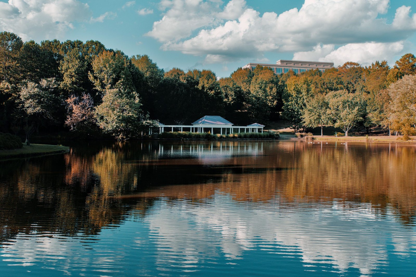 Lake with a white pavilion surrounded by trees
